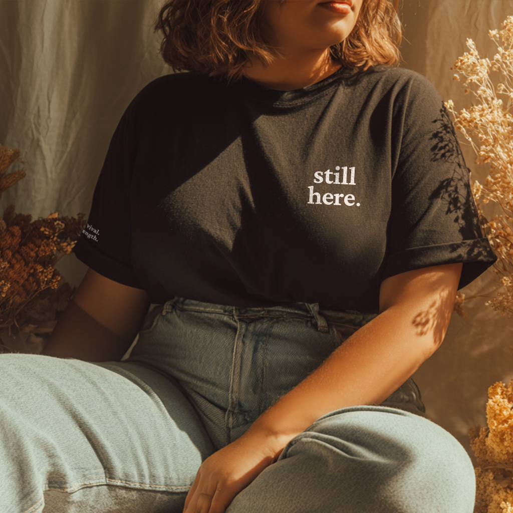 "still here." Everyday Edition T-Shirt | With Back and Sleeve Text