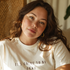 Woman wearing a "It’s Going to Be Okay” white t-shirt