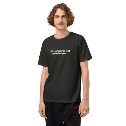 Man wearing a washed black t-shirt with a motivational quote “This Moment Is Not the End of You” reminder affirmation for resilience and healing.